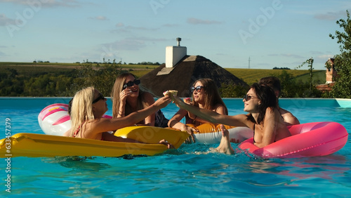 Multiethnic group of friends in the pool - young happy people have fun and enjoy summer time on vacation eating ice cream © Vladislav