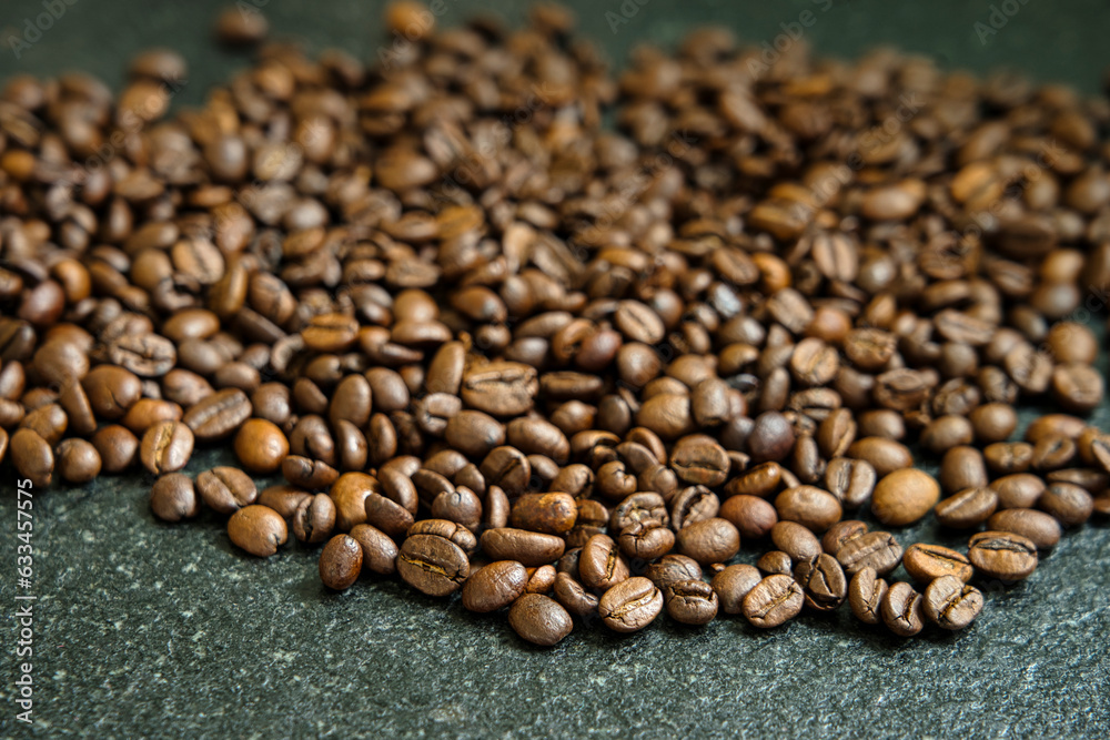 Pile of coffee beans on black granite table
