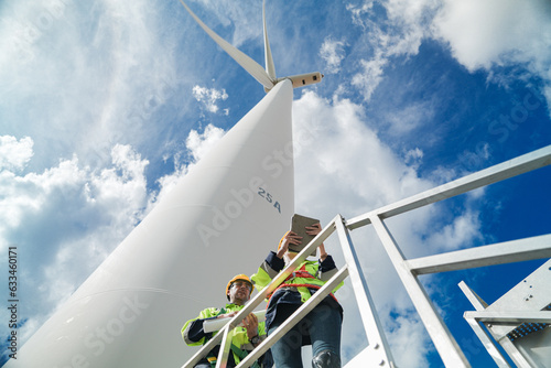 engineers working in fieldwork outdoors. Workers check and inspect construction and machine around the building project site. Wind turbines for electrical clean energy and environment sustainability.