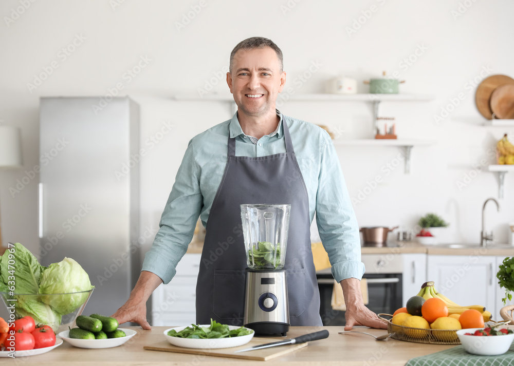 Mature man making smoothie in kitchen Mature man making smoothie in kitchen