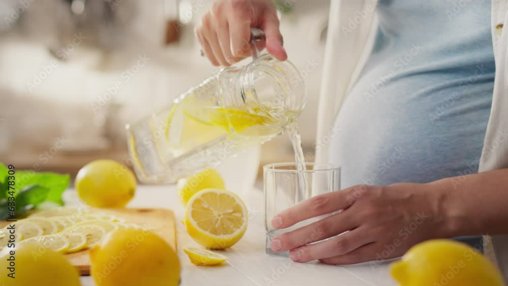 Half a lemon, white race girl decisively pours water on a fresh lemon in a home kitchen workplace. Steady camera motion expectant mother adding sparkling water to lemon juice new salad recipes, plant Half a lemon, white race girl decisively pours water on a fresh lemon in a home kitchen workplace. Steady camera motion expectant mother adding sparkling water to lemon juice new salad recipes, plant