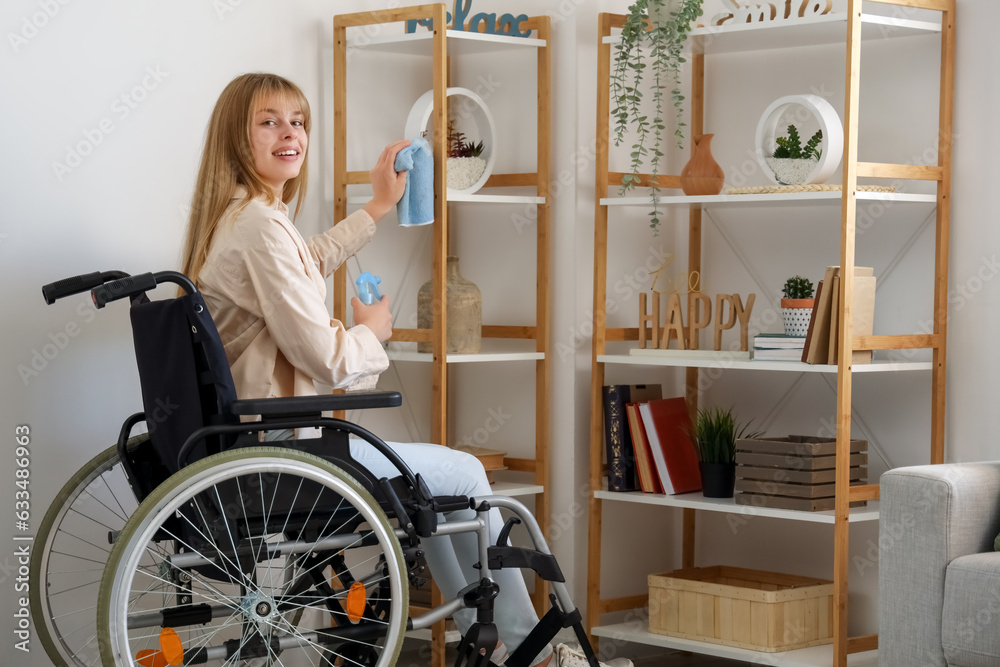 Young woman in wheelchair cleaning shelf at home Young woman in wheelchair cleaning shelf at home