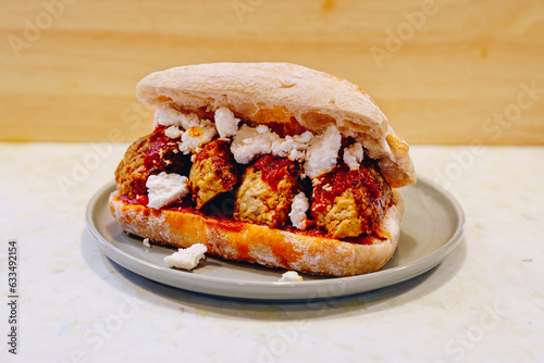 presentation of a plate with a meatball sandwich.