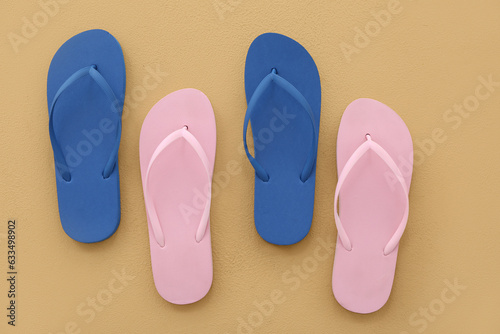 Colorful pairs of flip flops on beige background