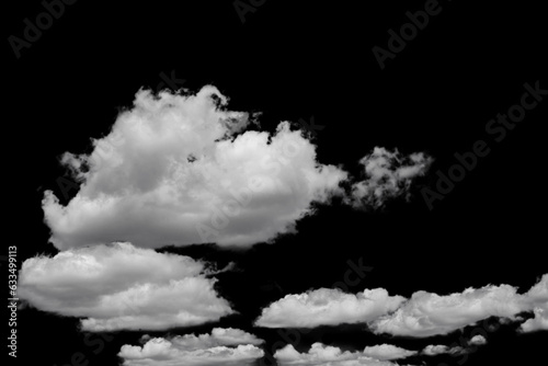 white fluffy clouds standing out against a black background and a blue sky