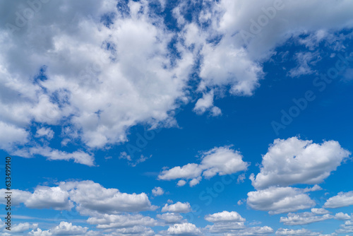 Fototapeta Naklejka Na Ścianę i Meble -  white fluffy clouds standing out against a black background and a blue sky
