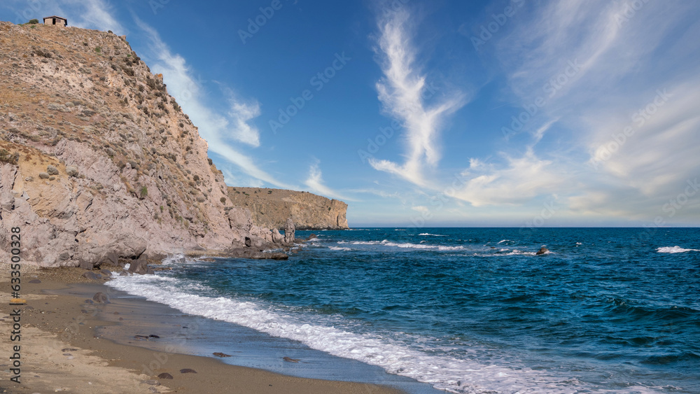 cloud clusters  in the sky on a deserted beach with magnificent cliffs and sea waves