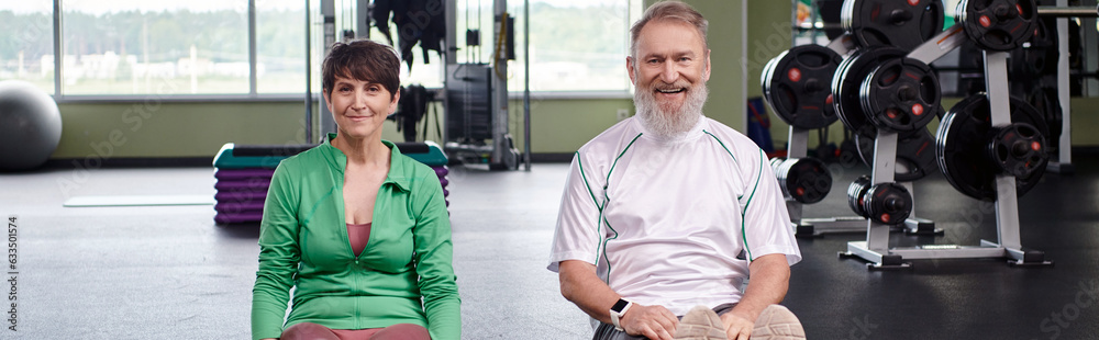 happy elderly couple sitting and looking at camera in gym, active seniors, healthy lifestyle, banner happy elderly couple sitting and looking at camera in gym, active seniors, healthy lifestyle, banner
