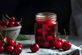 Homemade cherry preserves or jam in a glass jar surrounded by fresh cherries