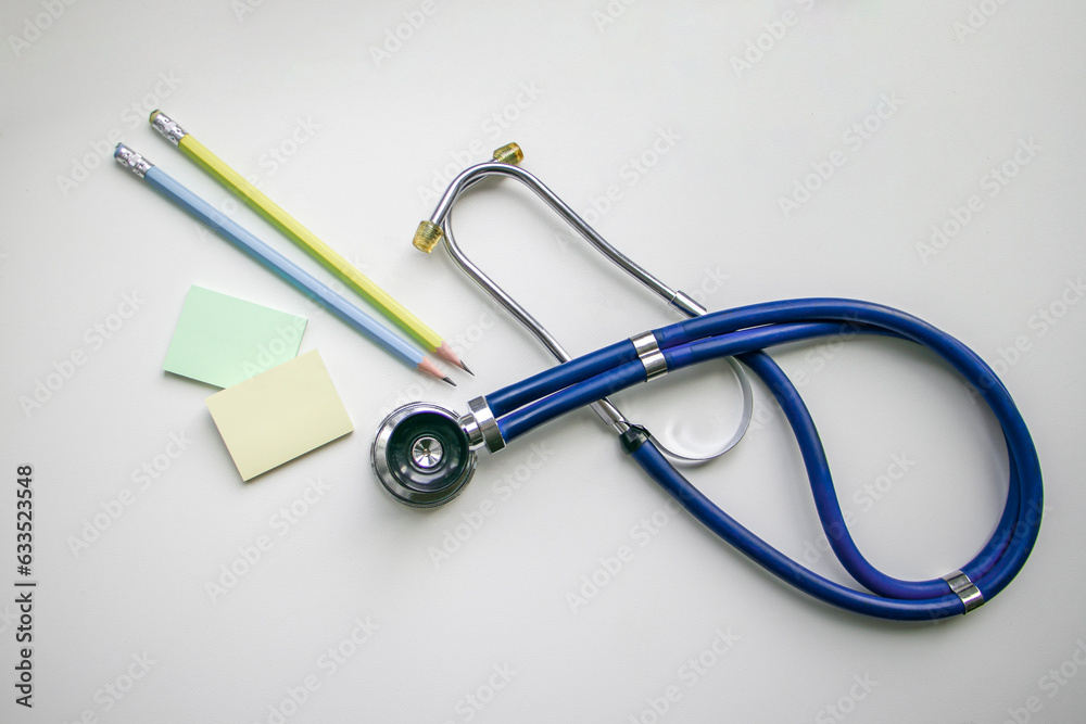 Stickers, pencils and a blue stethoscope on a white background. Health and wellness concept. horizontal photo Stickers, pencils and a blue stethoscope on a white background. Health and wellness concept. horizontal photo