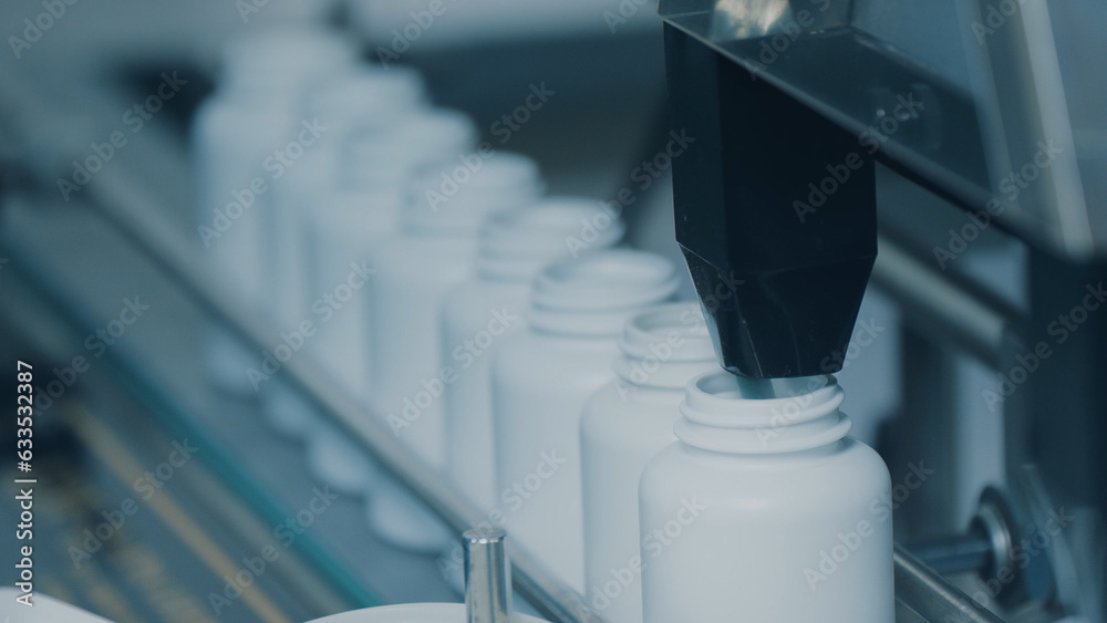 4K conveyor with moving empty white plastic tubes on the production line and filling with capsules. Automatic machine in the factory. Modern High-Tech Pharmacology Factory. Close Up, DOF