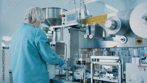 4K Blister Packing Machine. Woman works at the workplace. Tablet pharmaceutical blister packaging machine in supplement drug manufacture. Pharmaceuticals production line