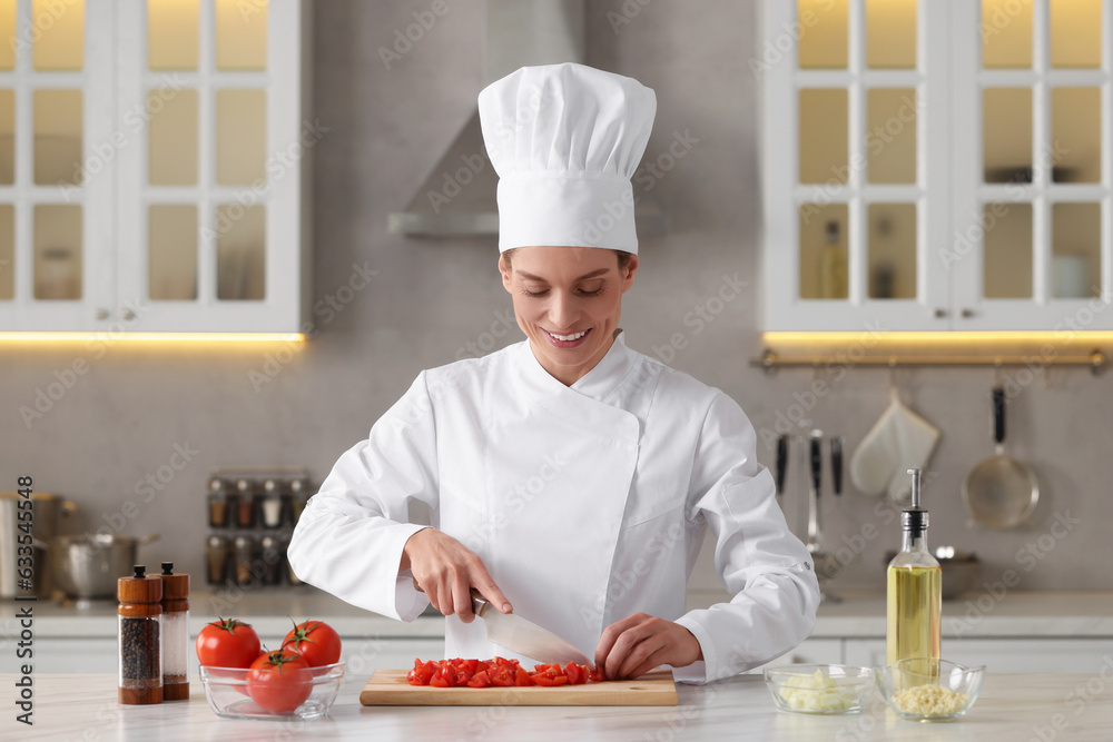 Professional chef cutting tomatoes at white marble table indoors Professional chef cutting tomatoes at white marble table indoors