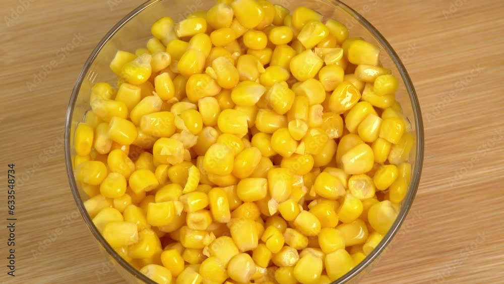 Sweet corn kernels rotate in glass bowl. Ingredient for mexican salad filled with vitamins