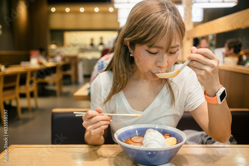 Asian women enjoy eating ramen noodles in japanese restaurant