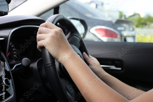 Hands holding steering wheel of car