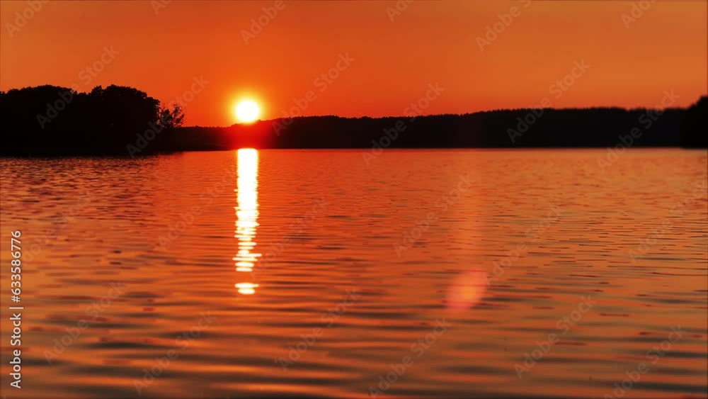 Sunset over the lake. View of the setting sun and the sun's rays reflecting in the water. Sunset over the lake. View of the setting sun and the sun's rays reflecting in the water.