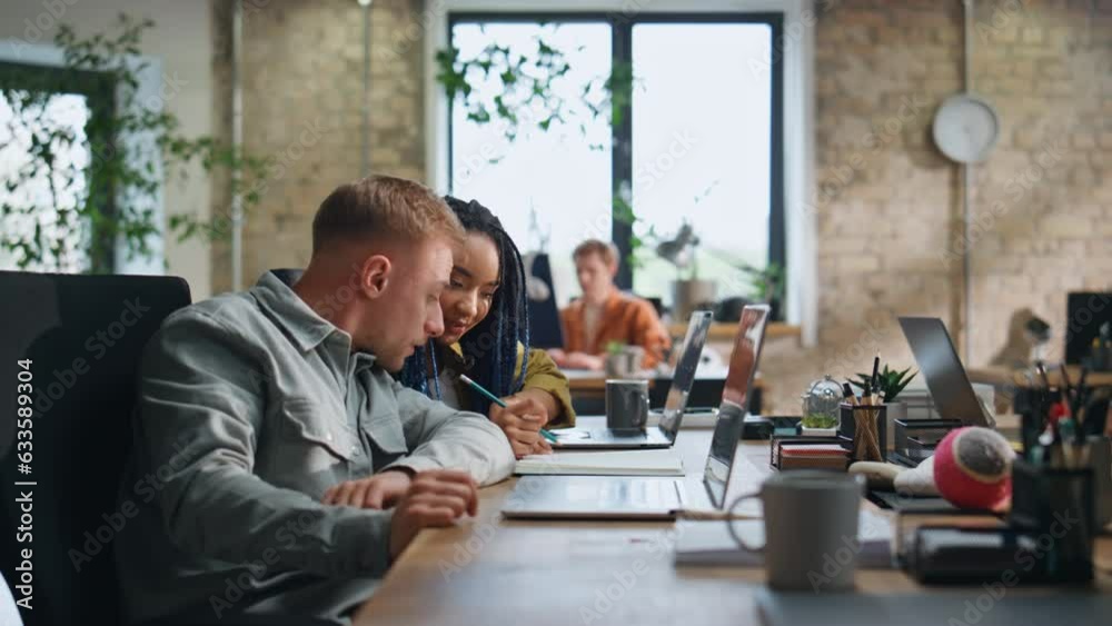 Woman asking advice colleague man sitting workspace. Multiracial team working Woman asking advice colleague man sitting workspace. Multiracial team working