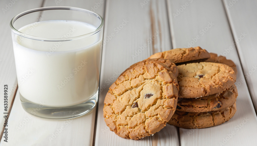 Tasty cookies and glass of milk on white wooden surface and colorful background Tasty cookies and glass of milk on white wooden surface and colorful background