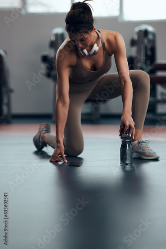 Fototapeta Naklejka Na Ścianę i Meble -  Sporty lady making pause in a gym after exercise.