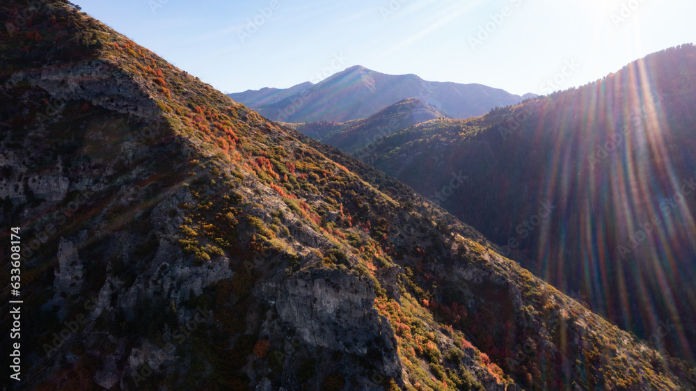 Sunrays over fall mountain range with tree foliage landscape