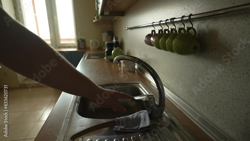 cozy home kitchen
a man approaches the sink, turns on the water to wash the dishes, but there is no water
disconnection of water supply
repair works at the waterworks