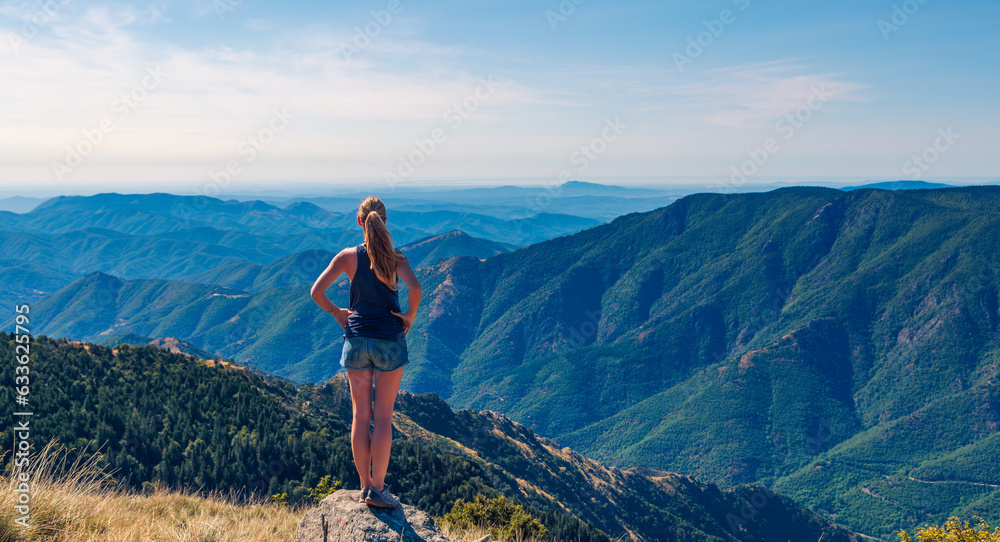 Hiker woman standing on peak enjoying panoramic view of mountain range ( Mont aigoual in France)- Hiking, successful,achievement concept