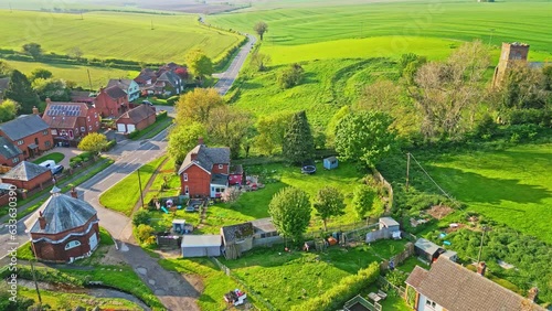 Aerial drone view captures Burwell village, once a medieval market town, including countryside fields, historic red brick houses, and the abandoned Saint Michael parish church on Lincolnshire's Wolds photo