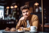 portrait of a young man having coffee in his bakery