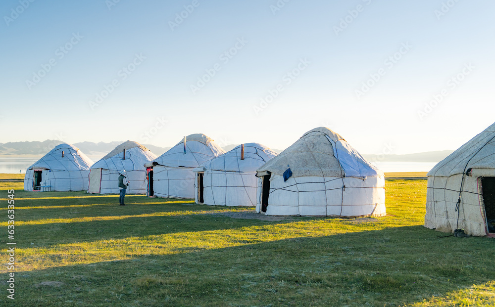 Yurt camp at Song Kul Lake during sunset. Travel to Kyrgyzstan to discover the nomadic life of the nomads camping and in yurt camps.