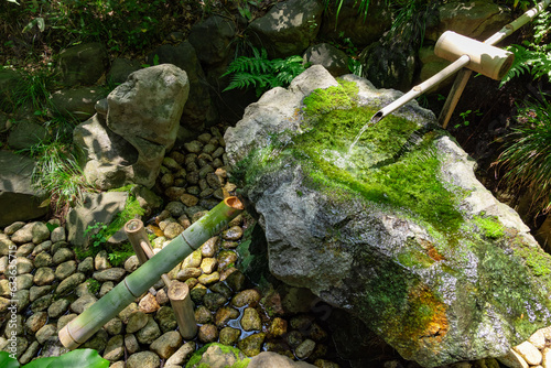 A Japanese Bamboo Water Fountain Shishi-Odoshi in Zen Garden photo