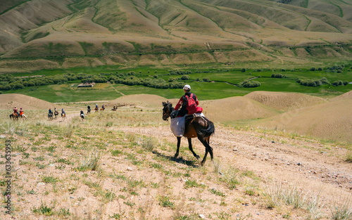 Kyrgyzstan steppes. Young boy rides a horse photo