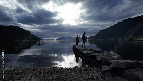 Two people taking photos of a fjord. Sjoholt, Norway photo