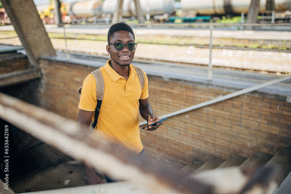 Young man with headphones and mobile phone on the train station Young man with headphones and mobile phone on the train station