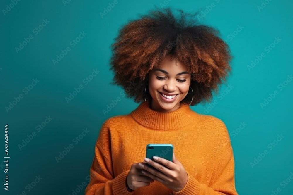 Woman with curly hair is using her smartphone and smiling Woman with curly hair is using her smartphone and smiling