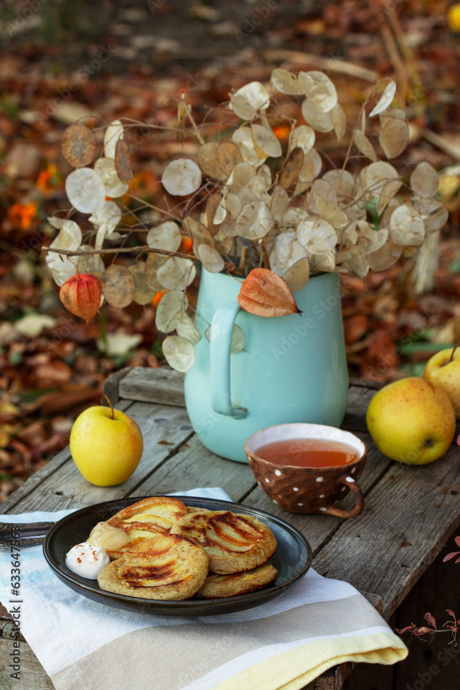 Whole wheat apple pancakes served with tea in the garden. Rustic style.
