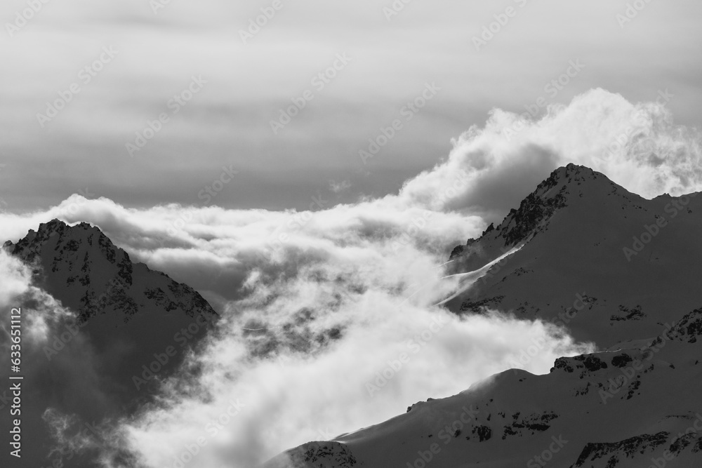 Sunlit Peaks Veiled by Clouds in black and white 