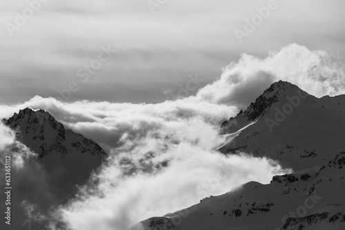 Sunlit Peaks Veiled by Clouds in black and white 