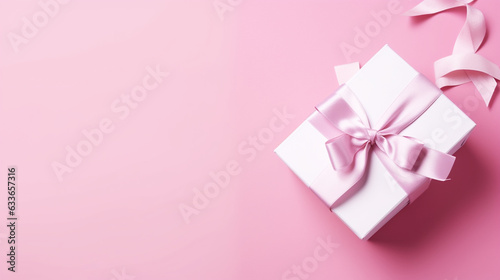 Holiday pink background with gift, gold satin bow. 