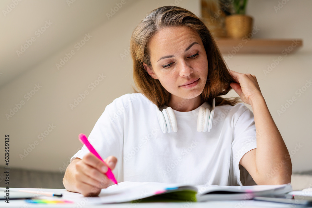 Brunette university female student doing homework. Brunette university female student doing homework.