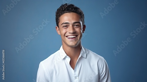 young man wearing white shirt smiling against blue background