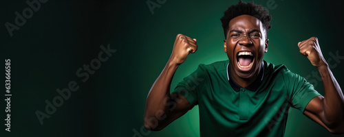Nigerian football fan celebrating a victory on green and white background with empty space for text 