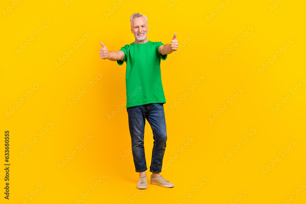 Full size portrait of positive nice aged man hands fingers demonstrate thumb up approval isolated on yellow color background Full size portrait of positive nice aged man hands fingers demonstrate thumb up approval isolated on yellow color background