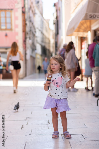Beautiful Caucasian girl with ice cream on the street of an ancient city in Croatia © Vladyslav