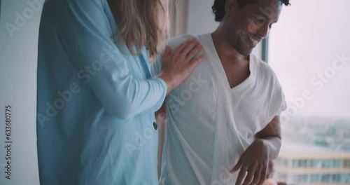 Young queer couple staring and smiling at each other looking at their elopment outfit. photo