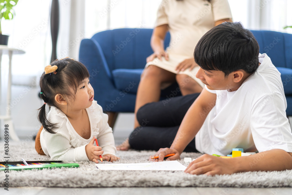 Portrait enjoy happy love asian family father and mother with little asian girl learn and study on table.Mom and dad with asian girl writing with book make homework in homeschool at home.Education Portrait enjoy happy love asian family father and mother with little asian girl learn and study on table.Mom and dad with asian girl writing with book make homework in homeschool at home.Education