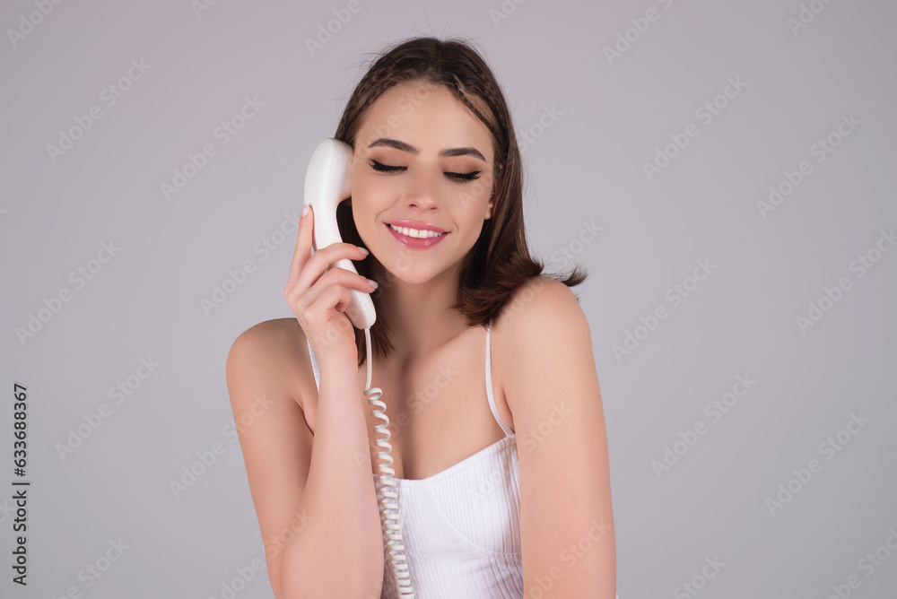 Studio portrait of woman talking on retro telephone. Retro landline telephone. Beauty young woman talking on a landline phone. Sexy girl talking by retro telephone. Woman hold telephone handset.