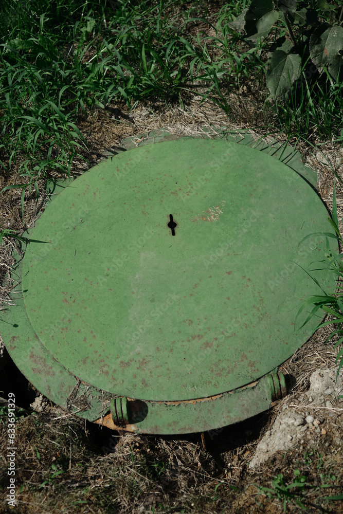 Green hinged cover sewer manhole. old design manhole covers, top view