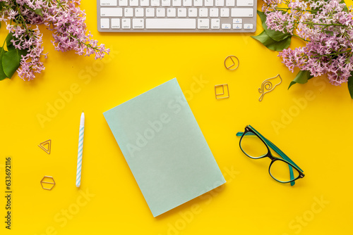 Female workplace with computer and spring flowers bouquet