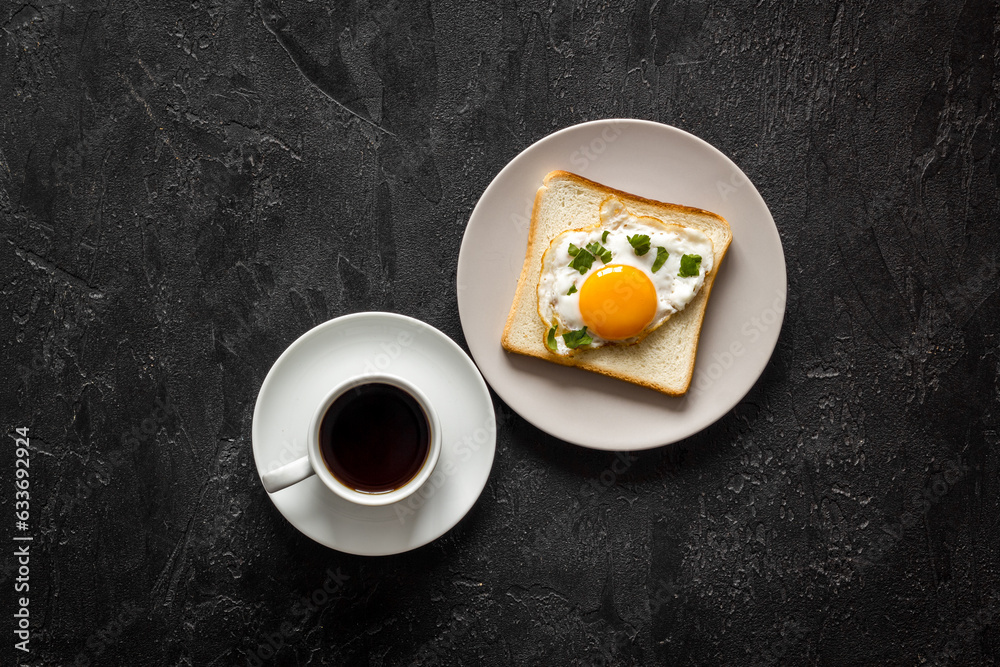 Breakfast with fried eggs on toast bread and cup of black coffee Breakfast with fried eggs on toast bread and cup of black coffee